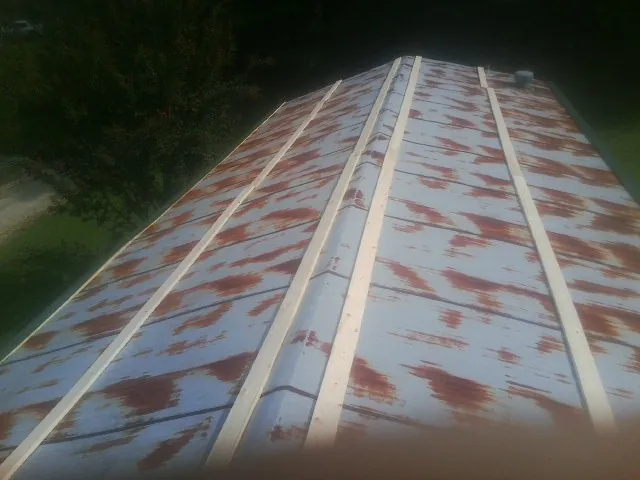 Rusted metal roof panels with new wood purlins before replacement — Storm Damage Roof Repair in Broxton by Roofing Brothers