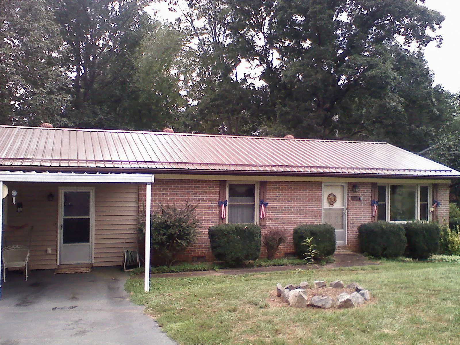 Bronze metal roof and carport on a brick ranch home — Roof Repair work by our crew in Broxton